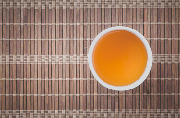 Cup of Chinese hot tea on bamboo mat background