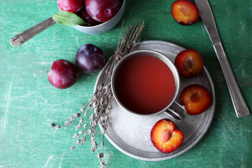 Delicious plum juice with fruits on wooden table close up