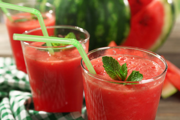 Glasses of watermelon juice on wooden table, closeup