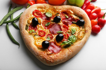 Heart shaped pizza and fresh vegetables isolated on white