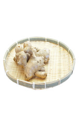 Fresh organic ginger in bamboo tray on white background