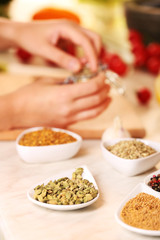Variety of spices in ceramic containers on the kitchen table