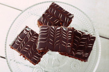 Served table with chocolate cakes on white wooden background