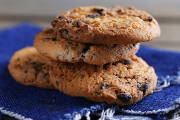 Cookies with chocolate crumbs on wooden table against blurred background, close up