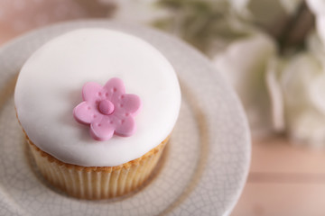 Fototapeta na wymiar Tasty cupcake on stand, on light background