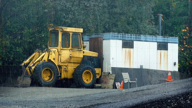 Construction Site With Digger In The Rain