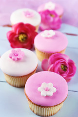 Tasty cupcakes on color wooden background