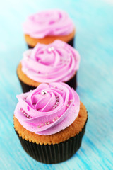 Tasty cupcakes on color wooden background
