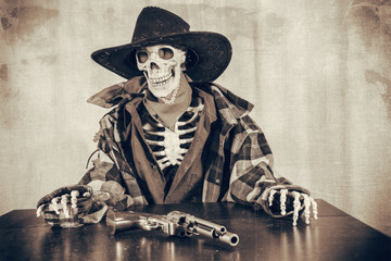 Old West Skeleton Revolver. Old west bandit outlaw skeleton at a poker table with a colt 45 pistol...