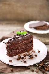 Chocolate cake with chocolate cream and fresh berries on plate, on wooden background