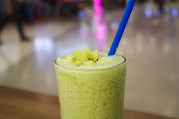 smoothie with fresh green kiwi fruits, wheat grass and herbs