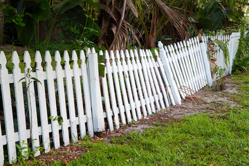 Old rickety fence in need of painting, fixing or replacing.