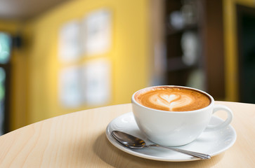Hot art Latte Coffee in a cup on wooden table and Coffee shop bl