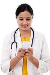 Female doctor text messaging on cellphone - 95777449