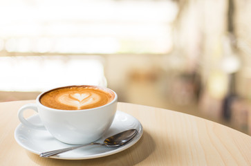 Hot art Latte Coffee in a cup on wooden table and Coffee shop bl