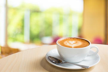 Hot art Latte Coffee in a cup on wooden table and Coffee shop bl