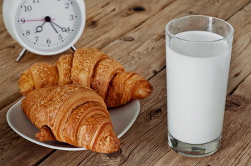 morning breakfast of milk and croissant on a wooden table