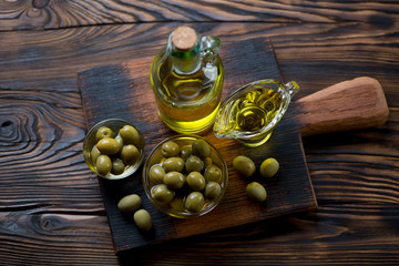 Olive oil and green olives, high angle view, studio shot