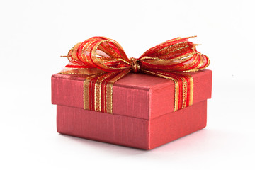 Red gift box with a red ribbon and bow in white isolated background