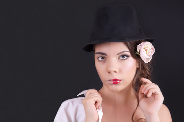 Portrait of the woman with a theatrical makeup on black background