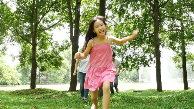 4K Asian family behide the tree and running together in the park