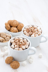 two cups of flavored cocoa with marshmallow and cookies