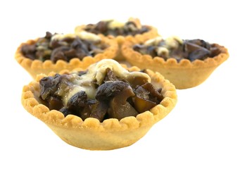 Isolated baked tartlets with mushrooms and cheese.