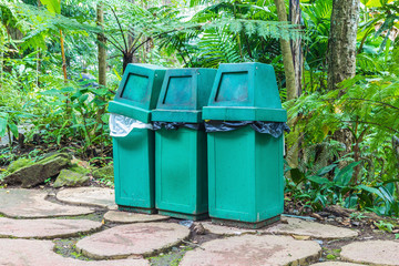 three green trash along the garden