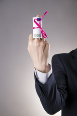 Money with ribbon in male hand on a gray background