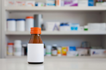 Blank white label of medicine bottle with blur shelves of drug i