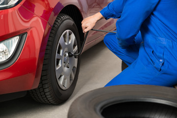 Mechanic Changing Tire In Garage