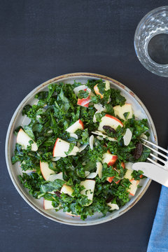 Kale salad with apples, almond slices and raisins. Overhead view