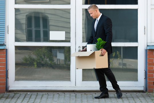 Businessman Carrying His Belongings In Box After Being Fired