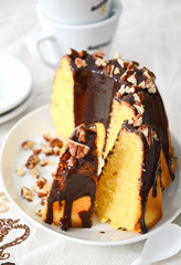 Bundt cake with chocolate glaze and pecan nuts sliced in pieces