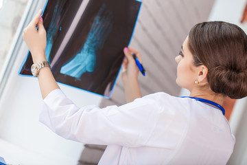 Fototapeta premium Female doctor looking at x-ray image