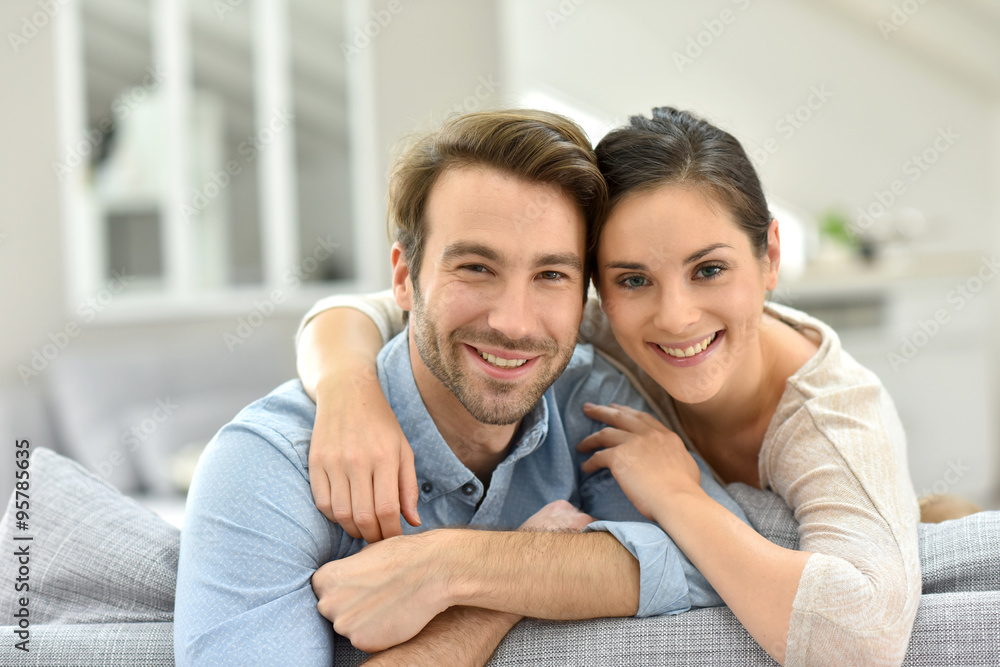 Wall mural Portrait of couple sitting in sofa at home