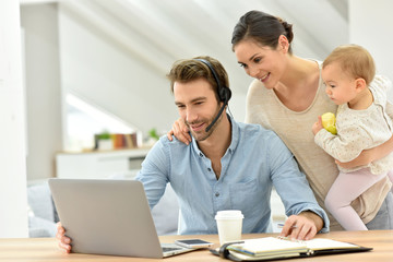 Man working from home, family around