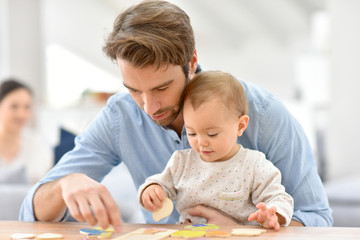Obraz na płótnie Canvas Man playing with baby girl at home