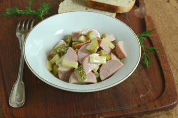 Traditional swiss salad with sausage, cheese and gherkins