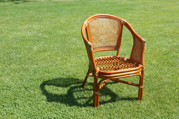 wicker chair on the background of fresh grass