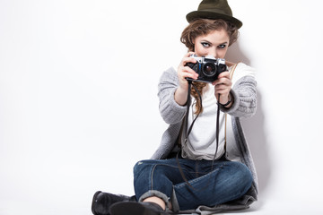 Studio portrait of a female hipster sitting with camera