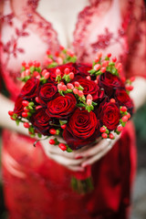 bride holding her red wedding bouquet of flowers