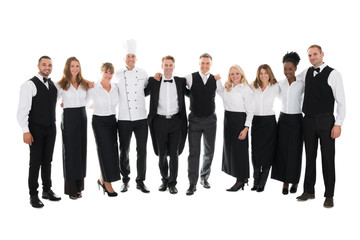 Fototapeta na wymiar Confident Restaurant Staff Standing With Arms Around