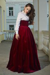 Girl in vintage dress on the porch of the manor