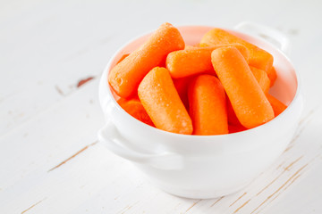 Baby carrot sticks in white bowl