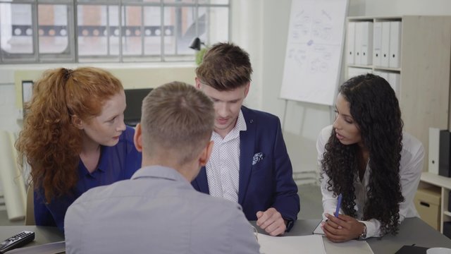 gesch&auml;ftsleute sitzen am besprechungstisch und unterhalten sich