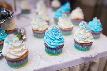 Blue wedding cup cakes on table