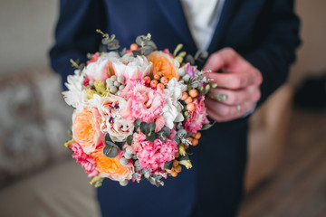 groom hold wedding bouquet