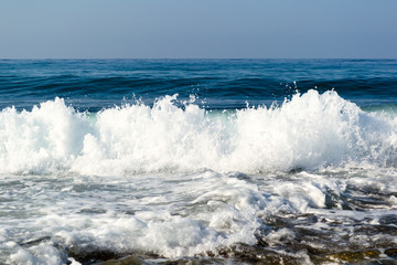 Waves breaking on a stony beach, forming sprays