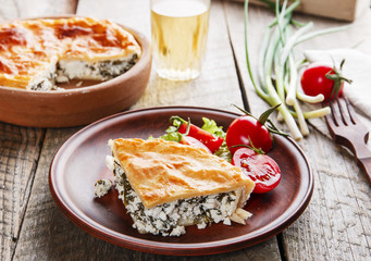 homemade pie with feta cheese and spinach in a clay bowl